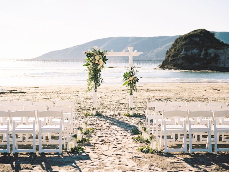 White wedding arch in front of beach